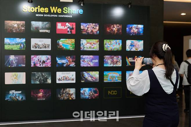 NDC 25 포토월에서 참가자가 사진을 찍고 있다. (사진=넥슨)