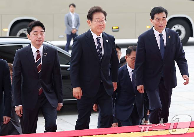 이재명 대통령이 26일 취임 이후 첫 추가경정예산안 시정연설을 위해 서울 여의도 국회에 도착하고 있다. 왼쪽부터 강훈식 비서실장, 이 대통령, 김민기 국회사무총장. 2025.6.26/뉴스1 ⓒ News1 국회사진기자단