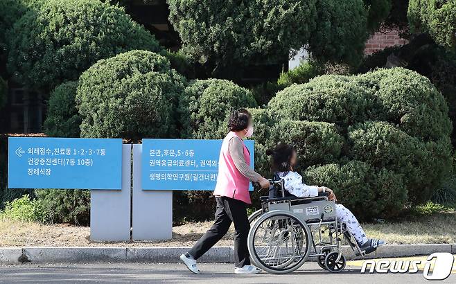 지난해 4월 8일 대구의 한 대학병원에서 간병인이 입원환자의 휠체어를 밀며 산책하고 있다. 2024.4.8/뉴스1 ⓒ News1 공정식 기자