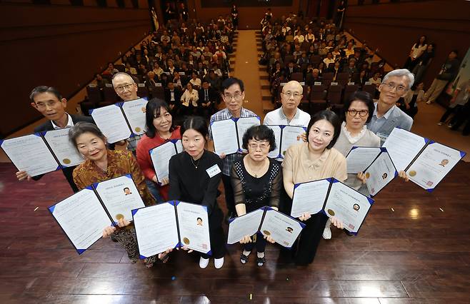 이날 서울출입국·외국인청이 서울 용산구 전쟁기념관에서 외국 국적 동포 103명을 초청해 국적 증서 수여식을 연 가운데, 국적 회복자 대표단이 국적 증서를 펼치고 있다. /장경식 기자