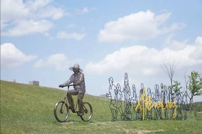 2019년 5월 세종시 세종호수공원 한쪽에 있는 상징물이 놓여 있다. 밀짚모자를 쓰고 자전거를 탄 노무현 전 대통령 뒤로 한 무리의 사람들이 따라가고, 노란 글씨로 ‘사람 사는 세상’이라고 적혀 있다. 박기용 기자