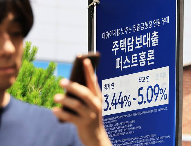 서울 시내 은행 앞 대출 홍보물을 지나는 시민. 연합뉴스