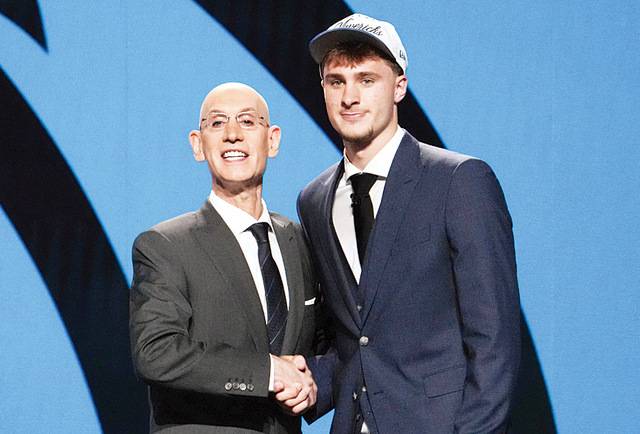 쿠퍼 플래그(오른쪽)가 26일(한국시간) 열린 2025 NBA 신인드래프트에서 전체 1순위로 댈러스 매버릭스의 지명을 받은 뒤 아담 실버 NBA 총재와 악수하고 있다. AFP연합뉴스