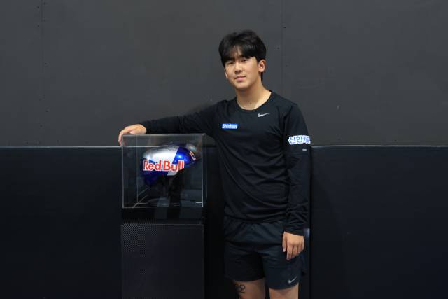 후원사 로고가 새겨진 헬멧 옆에서 포즈를 취한 이채운. 사진 제공=브리온컴퍼니