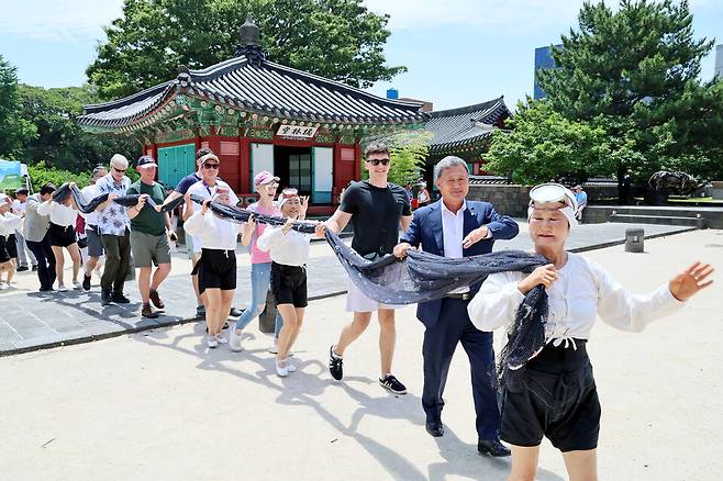 크루즈관광객들과 김완근 제주시장(앞에서 두 번째)이 제주 목관아에서 해녀 공연을 함께 체험하고 있다. ⓒ제주시 제공