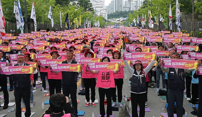 지난 26일 최저임금위원회 7차 전원회의가 열리고 있는 정부세종청사 최저임금위원회 앞에서 열린 최저임금 인상 촉구 결의대회‘에서 민주노총과 한국노총 소속 조합원들이 최저임금 인상을 촉구하고 있다. [연합]
