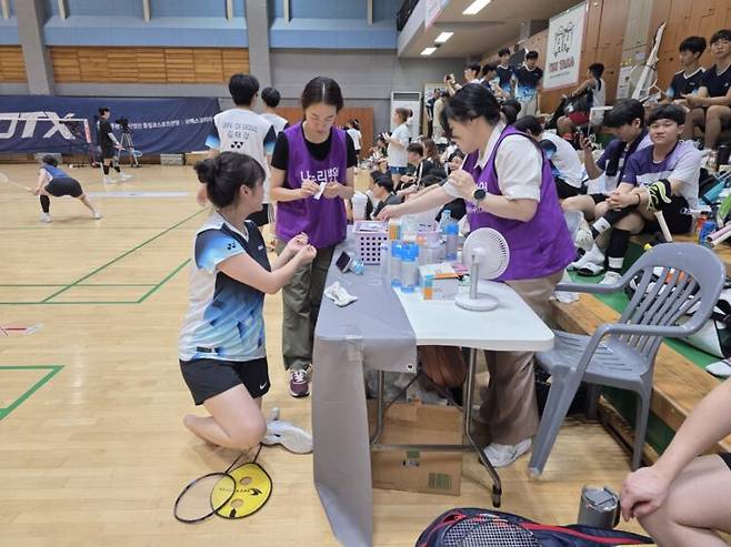 이날 대회에 현장 의료지원팀으로 참여한 강윤희·최혜미 간호사가 발을 다친 선수의 상처를 치료하고 있다. [사진=코메디닷컴]