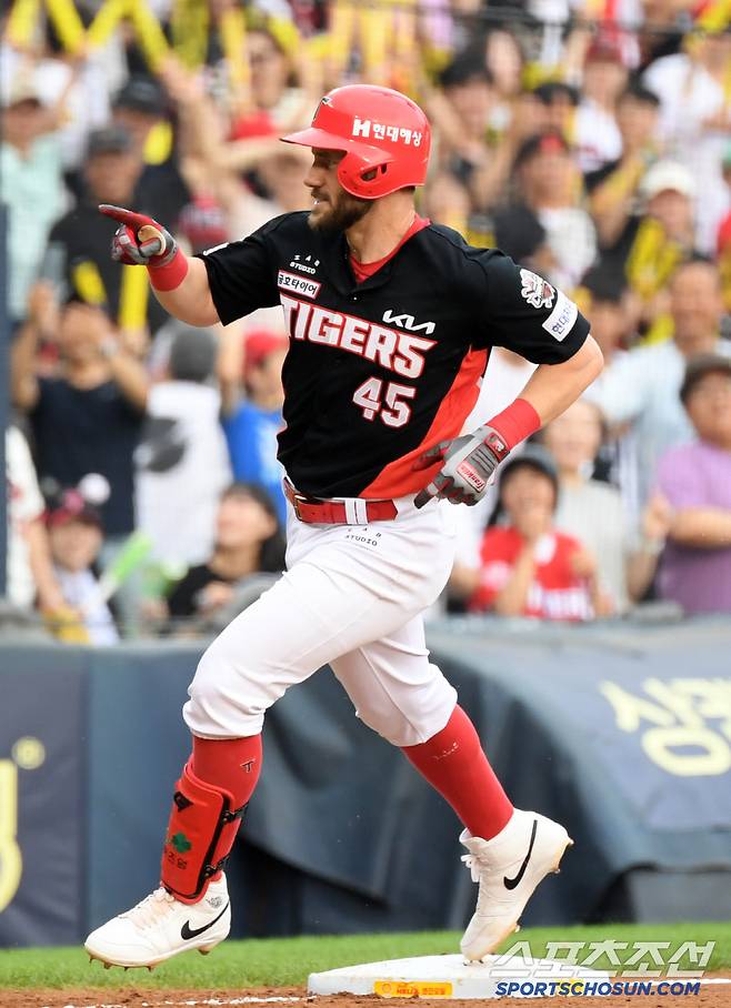 무릎을 꿇고 타격해 홈런포로 연결한 위즈덤이 더그아웃을 향해 손짓하고 있다.