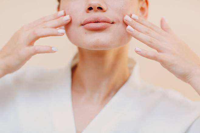 SNS에서 인기를 끄는 ‘얼굴 요가’가 실제로 얼굴 탄력과 윤곽 개선에 효과가 있다는 전문가 분석이 나왔다. 과장된 표정을 반복하거나 얼굴을 손으로 마사지하며 얼굴 근육을 자극하는 방식으로, 피부 아래 구조를 지탱하고 림프 순환 개선에도 도움을 줄 수 있다는 설명이다. 특히 볼 부위에서는 근육 반응이 커, 일부 실험에서 변화가 관찰됐지만 꾸준한 실천이 필요하다는 조언도 함께 나왔다. 얼굴 긴장 완화와 자각 훈련 측면에서도 긍정적 평가가 이어지고 있다. (사진=게티이미지)