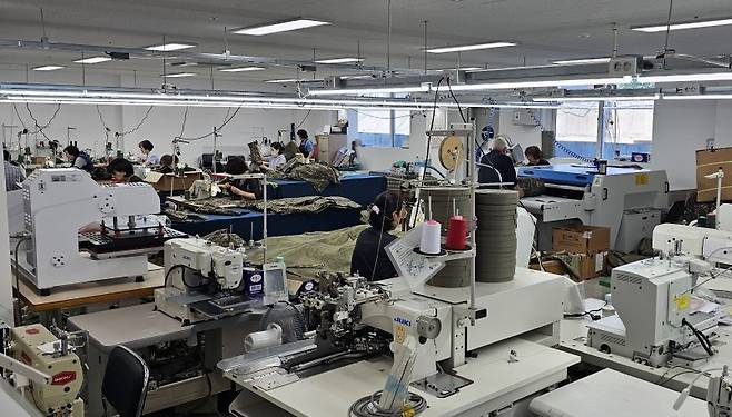 지난 27일 찾은 부산서동의류제조지원센터 현장. 1층 스마트제조 시범공장에서 종사자들이 국방부에 납품할 군용우의를 만들고 있다. 사진=변옥환 기자