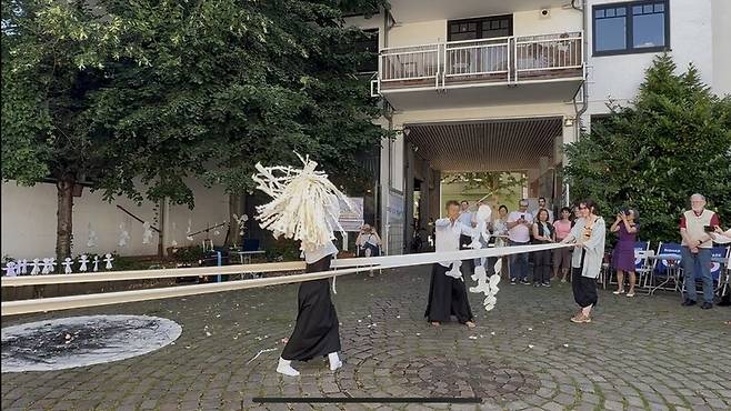 독일 본 지역 여성박물관에 영구 설치된 소녀상의 제막식이 열린 28일(현지시각), 행사에 참여한 이들은 구슬픈 노래 가사에 몸을 맡기고 ‘길베’ 의식을 펼쳤다. 흰 무명천을 길게 펼쳐 그 사이를 뚫고 사람들은 손짓하며 행진했다. 새로운 존재로 거듭난 망자를 좋은 곳으로 보내는 의식이다. 사진 장예지 특파원