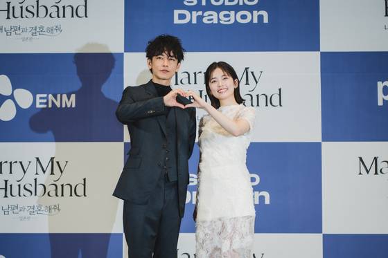Actors Sato Takeru and Koshiba Fuka pose for photos during a press conference held on June 26 for the Japanese remake of ″Marry My Husband″ drama series. [CJ ENM]
