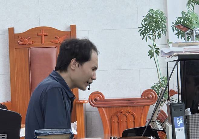 29일 행복한 교회 예배 중 피아노 반주를 맡은 청년 성도가 건반 앞에 앉아 연주에 집중하고 있다.