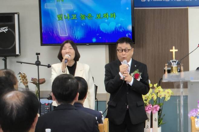 고성선 목사와 김정자 사모가 외부 교회에서 함께 찬양하고 있다.