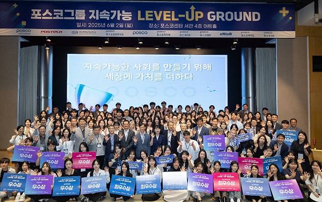 6월 2일 포스코센터에서 열린 2025년 1학기 포스코그룹 지속가능 레벨업그라운드에서 참가자들이 행사 슬로건 타월을 들고 단체사진을 촬영하고 있다.