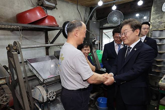 이재명 대통령이 13일 기본소득 실시지역 현황점검을 위해 방문한 경기도 연천군의 한 방앗간에서 주인과 대화하고 있다. 26년 동안 방앗간을 운영했다는 주민은 "기본소득이 나오면서 저희가 매출이 늘었다"며 "(매출이) 늘어나는 바람에 세금을 내고 있다. 그래도 좋다"고 했다. 이 주민은 전날 기준으로 매출에서 지역화폐 결제가 차지하는 비중이 80% 수준이라고 설명했다. 연합뉴스