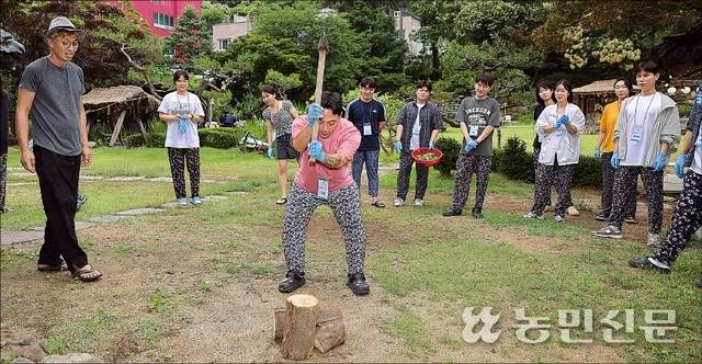 몸뻬 바지를 입은 참가자 ‘마초’가 장작 패기에 도전하고 있다. 요령은 도끼의 무게를 이용해 내려치는 것이다.