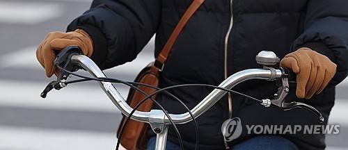 자전거 출근  (서울=연합뉴스) 서대연 기자 = 광화문네거리에서 한 시민이 장갑을 끼고 자전거를 타고 있다. 2023.12.13 dwise@yna.co.kr
