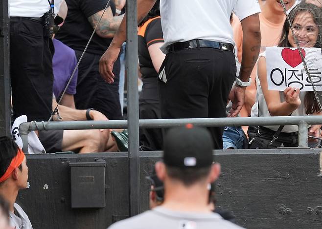 샌프란시스코 자이언츠 팬으로 보이는 한 여성 팬이 30일(한국시각) 레이트필드에서 열린 시카고 화이트삭스전에서 한글로 '이정후'와 하트가 적힌 종이를 들고 이정후(아래 왼쪽)를 바라보고 있다. AP연합뉴스