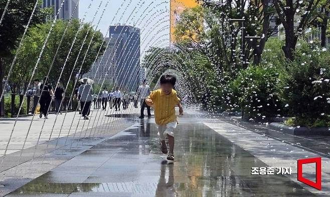 낮 최고기온이 33도를 웃돌고 후텁지근한 날씨가 이어진 19일 서울 종로구 광화문광장 분수터널을 찾은 아이가 물놀이를 즐기고 있다. 기상청은 내일부터 장마전선의 영향으로 전국에 많은 양의 비가 올것으로 예보했다. 2025.6.19 조용준 기자