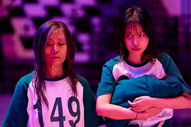 ‘오징어 게임3’의 참가자 ‘금자’(배우 강애심)와 신생아를 안은 ‘준희’(조유리). 데스 게임 한복판에서 탄생한 생명을 지키는 것은 상투적이면서도, 매우 ‘기훈답다’는 평가를 받고 있다./넷플릭스