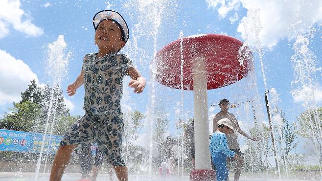 전북 전 지역에 폭염특보가 발효된 29일 전북 전주시 송천동 한 공원을 찾은 한 어린이가 바닥분수에서 물놀이를 하며 더위를 식히고 있다./뉴스1