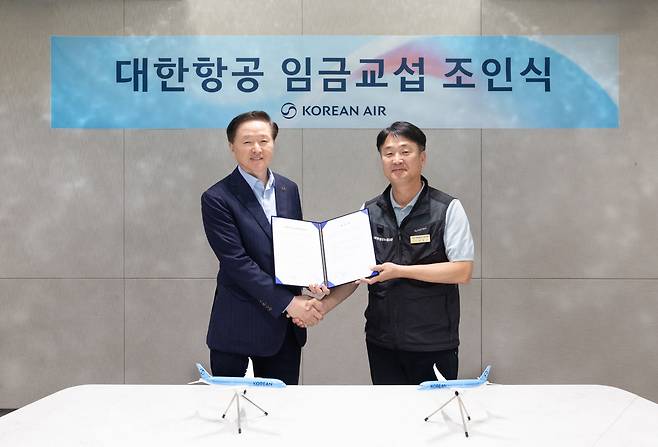 지난 26일 서울 강서구 대한항공 본사에서 개최된 대한항공 ‘2025년 임금교섭 조인식’에서 우기홍(왼쪽) 대한항공 부회장과 조영남 대한항공 노동조합위원장이 악수를 하고 있다./대한항공 제공