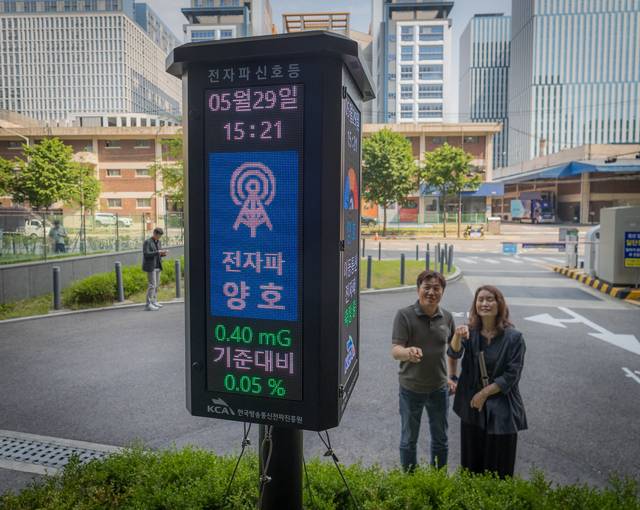 시민들이 지난 5월 29일 서울 금천구 SK브로드밴드 가산데이터센터 입구에 세워진 전자파 신호등을 살펴보고 있다. 전자파 신호등은 한국방송통신전파진흥원(KCA)이 자체 개발한 IoT(사물인터넷) 기반 이동통신 기지국 전자파 모니터링 측정기와 연동한 서비스로, 실시간 전자파 측정 정보를 기지국 인근 주민들에게 3색의 신호등으로 알기 쉽게 제공한다, 박동욱기자 fufus@