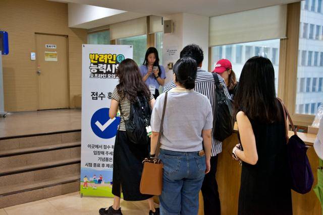 지난 28일 서울시청 서소문청사에서 열린 '2025 반려인능력시험 오프라인 모의고사'에 응시한 참가자들이 접수 확인 후 입장하고 있다.