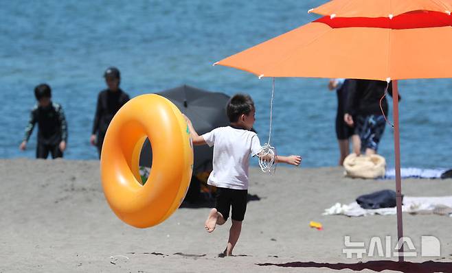 [제주=뉴시스] 우장호 기자 = 제주 북부지역에 올해 첫 폭염특보가 내려진 29일 제주시 이호테우해수욕장에서 튜브를 든 아이가 바다를 향해 달려가고 있다.기상청에 따르면 당분간 폭염특보가 발표된 제주도북부, 동부, 중산간을 중심으로 뜨겁고 습한 남풍류가 유입돼 무더운 날씨가 이어질 것으로 전망된다. 2025.06.29. woo1223@newsis.com