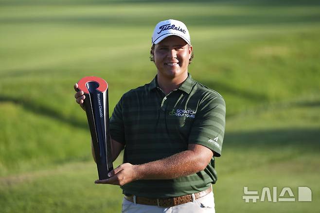 [디트로이트=AP/뉴시스] 알드리치 포트기터(남아공)가 29일(현지 시간) 미 미시간주 디트로이트 GC에서 열린 미국프로골프(PGA) 투어 로켓 모기지 클래식 정상에 올라 트로피를 들고 포즈를 취하고 있다. 포트기터는 최종 합계 22언더파 266타로 맥스 그레이서먼, 크리스 커크(미국)와 동타를 이뤄 연장 끝에 우승컵을 들어 올렸다. 2025.06.30.