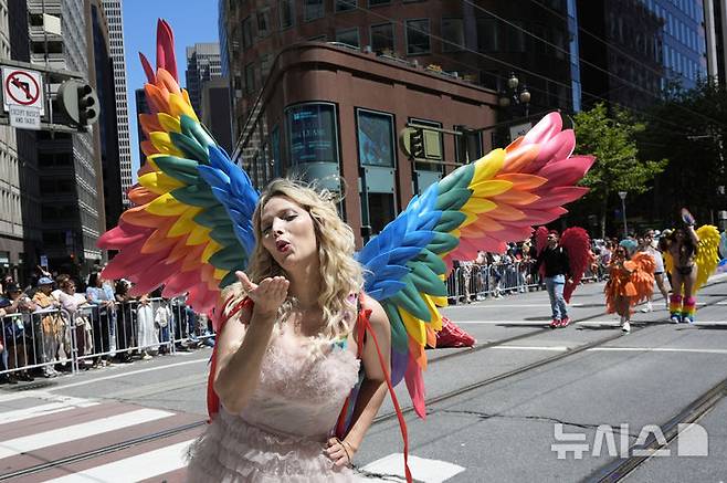 [샌프란시스코=AP/뉴시스] 29일(현지 시간) 미 캘리포니아주 샌프란시스코에서 열린 프라이드 퍼레이드에서 무지개색 날개를 착용한 참가자가 손 키스를 날리고 있다. 매년 6월은 '세계 성소수자 프라이드의 달'로 세계 곳곳에서 기념행사가 열린다. 2025.06.30.