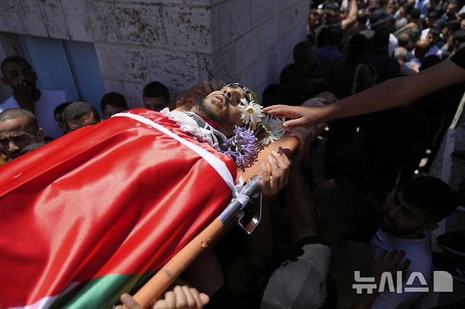 [카프르 말리크(요르단강 서안)=AP/뉴시스]지난 25일 극우 유대인 정착민들의 요르단강 서안 카프르 말리크 마을 공격으로 숨진 한 팔레스타인 남성의 장례식이 26일 치러지고 있다. 요르단강 서안의 이스라엘 정착민 수십명이 29일 밤 요르단강 서안의 이스라엘 군사기지 주변에서 불을 지르고 군용 차량을 파손하고 군인들을 공격했다고 이스라엘 군 당국이 30일 밝혔다. 이는 지난 25일100명이 넘는 이스라엘 정착민들이 요르단강 서안 크파르 말리크 마을을 불태우고 팔레스타인인들에게 총격을 가해 이스라엘군이 정착민 5명을 체포한 데 분노했기 때문이다. 2025.06.30.