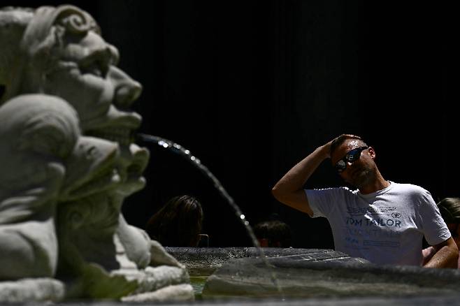 사진은 이탈리아 로마의 한 분수대에서 물로 머리를 식히는 관광객. 연합뉴스