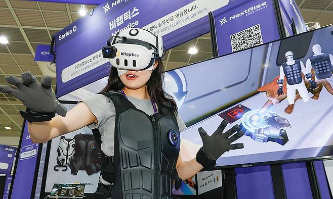 지난 26일 서울 강남구 코엑스에서 열린 ‘넥스트라이즈 2025’에서 한 참가자가 VR 웨어러블 햅틱 기기를 체험하고 있다. 최상수 기자