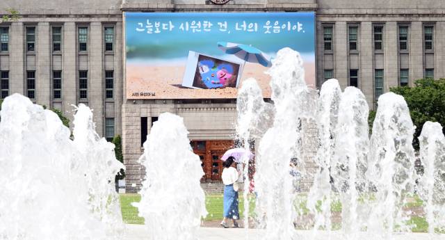 서울 전역에 올해 첫 폭염주의보가 발령된 30일 시민들이 서울 중구 서울도서관 꿈새김판 앞을 지나고 있다. 오승현 기자