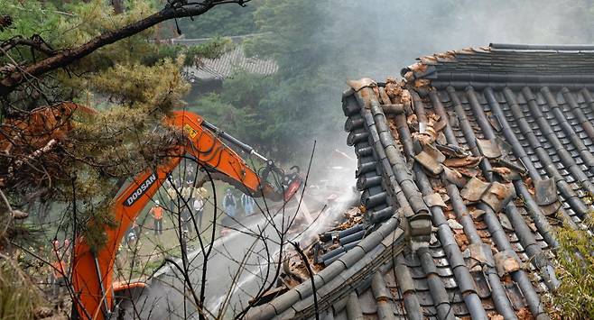 30일 오후 서울 성북구에 위치한 명승 성북동 별서 내 송석정에서 화재가 발생해 소방대원들이 포크레인을 이용해 진화 작업을 하고 있다. (공동취재) 2025.06.30.  뉴시스.