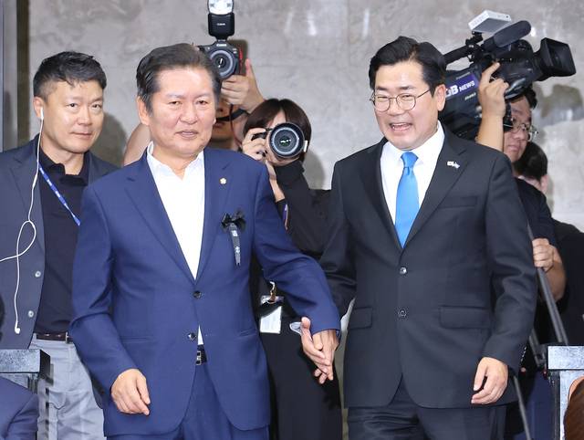 더불어민주당 8·2 전당대회 당대표 후보로 출마한 정청래(왼쪽부터)·박찬대 의원이 지난 6월24일 국회에서 열린 민주당 의원총회에 나란히 손을 잡고 참석하고 있다.<연합뉴스 사진>