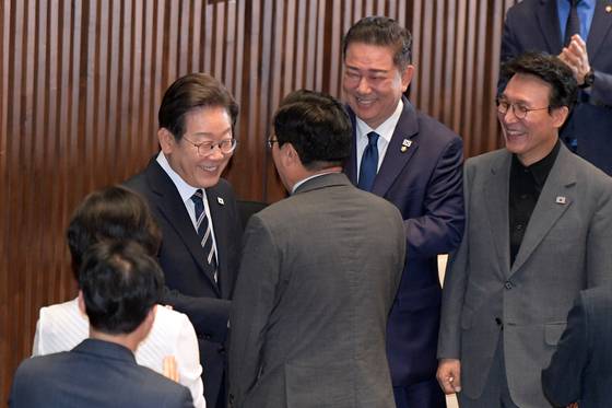 이재명 대통령이 26일 서울 여의도 국회에서 2025년도 제2회 추가경정예산안에 대한 정부의 시정연설을 위해 본회의장에 들어서며 더불어민주당 김병기 당대표 직무대행 겸 원내대표, 박찬대 의원, 김민석 국무총리 후보자 등과 인사를 하고 있다. [국회사진기자단] 2025.06.26.