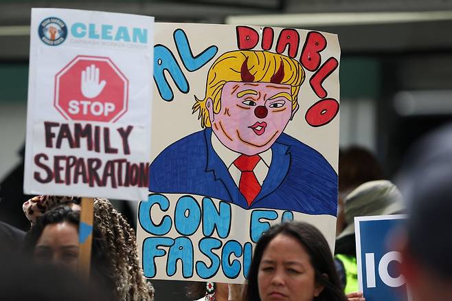 캘리포니아주에서 연방 정부의 미등록 이민자 단속에 반대하는 시위대가 플래카드를 들고 서있다. AFP연합뉴스