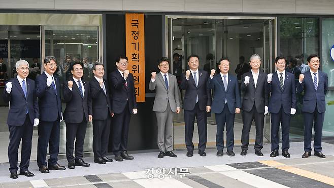 이한주(왼쪽 다섯 번째) 국정기획위원장과 국정기획위원회 진성준, 김용범, 방기선 부위원장 등 참석자들이 지난달 16일 서울 종로구 정부서울청사 창성동 별관에서 열린 국정기획위원회 현판식에서 현판 제막을 마친 후 기념촬영을 하고 있다. 문재원 기자
