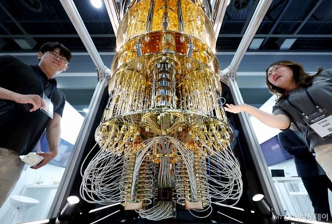 [서울=뉴시스] 김진아 기자 = 24일 서울 서초구 aT센터에서 열린 '퀀텀 코리아 2025'에서 관람객들이 IBM '퀀텀 시스템 원(Quantum System One)' 양자컴퓨터 모형에 대한 설명을 듣고 있다. 2025.06.24.