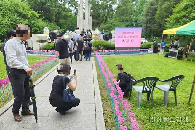 지난 29일 서울 서초구 양재시민의숲에서 진행된 삼풍백화점 붕괴 참사 30주기 추모식에서 한 유가족이 희생자인 동생의 이름표 앞에서 사진을 찍고 있다. 이영기 기자.