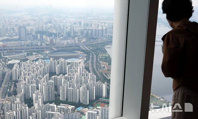 [서울=뉴시스] 박주성 기자 = 정부가 수도권과 규제지역의 주택담보대출 한도를 6억원으로 제한하는 초강수 조치를 펴면서 서울 아파트의 74%가 주담대 제한 영향권에 들게 된다는 분석이 나왔다. 부동산R114의 수도권 아파트 평균 시세를 보면 서울 전체 25개 구 가운데 18개 구의 대출액이 종전보다 줄어들 것으로 예상했다.  사진은 29일 서울 송파구 롯데월드타워 전망대 서울스카이에서 바라본 서울시내 아파트의 모습. 2025.06.29. park7691@newsis.com