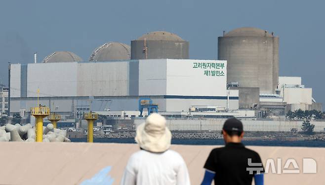 [부산=뉴시스] 하경민 기자 = 26일 오후 부산 기장군의 한 해안가에서 시민들이 고리원전 1호기를 바라보고 있다. 원자력안전위원회는 이날 회의를 열어 우리나라 최초 원자력발전소인 고리원전 1호기 해제승인을 여부를 결정한다. 원안위가 고리원전 1호기 해체승인을 의결하면 2017년 영구정기 결정 8년 만에 본격적인 해체에 돌입하게 된다. 고리 1호기는 1978년 4월29일 상업 운전을 시작했다. 2025.06.26. yulnetphoto@newsis.com