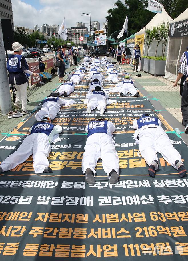 [서울=뉴시스] 김금보 기자 = 전국장애인부모연대 회원들이 7일 서울 여의도 국회 정문 앞에서 발달장애인 관련 예산과 권리 확대를 요구하며 오체투지를 하고 있다. 2025.07.01. kgb@newsis.com