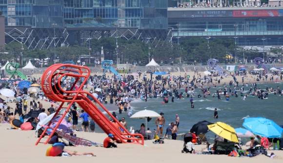 지난 21일 조기 개장한 해운대해수욕장에서 29일 피서객들이 물놀이하며 더위를 식히고 있다.  부산 연합뉴스