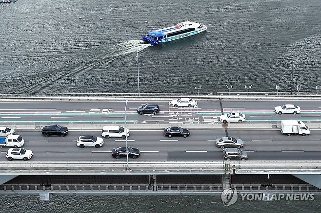 한강버스 '도로 대신 물길을 따라' (서울=연합뉴스) 서대연 기자 = 한강버스 체험운항이 시작된 1일 서울 청담대교 인근에서 한강버스가 운행하고 있다.
    한강버스는 서울시가 한강 유역에 처음 도입하는 친환경 수상 대중교통수단으로 마곡∼망원∼여의도∼옥수∼압구정∼뚝섬∼잠실 7개 선착장, 약 31.5㎞의 거리를 오간다. 정식 취항은 9월로 예정돼 있으며 이날부터 8월 30일까지는 매주 화·목·토요일에 시민 체험 운항이 열린다. 2025.7.1 dwise@yna.co.kr
