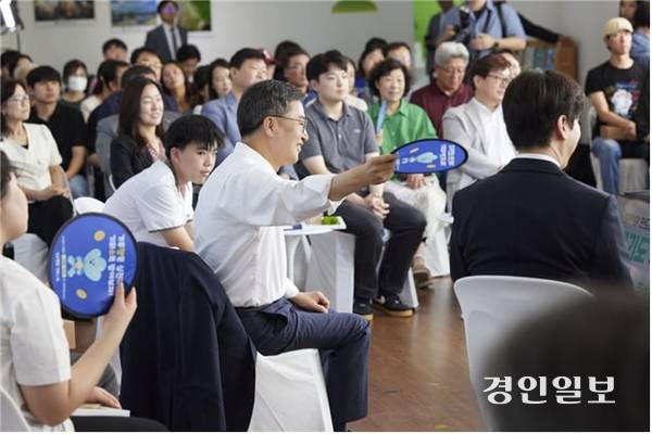 김동연 경기도지사가 지난달 30일 시흥에코센터에서 진행된 ‘경기도 기후도민총회 출범식’에서 도민 참가자에게 부채질을 해주고 있다. 2025.6.30 /경기도 제공