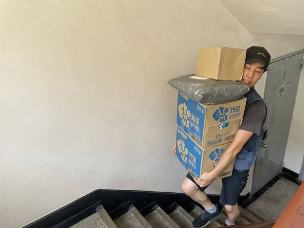 택배 노동자 정태연씨가 1일 광주시 동구 지산동에 있는 한 5층짜리 다세대 주택에서 택배를 나르기 위해 계단을 오르고 있다.